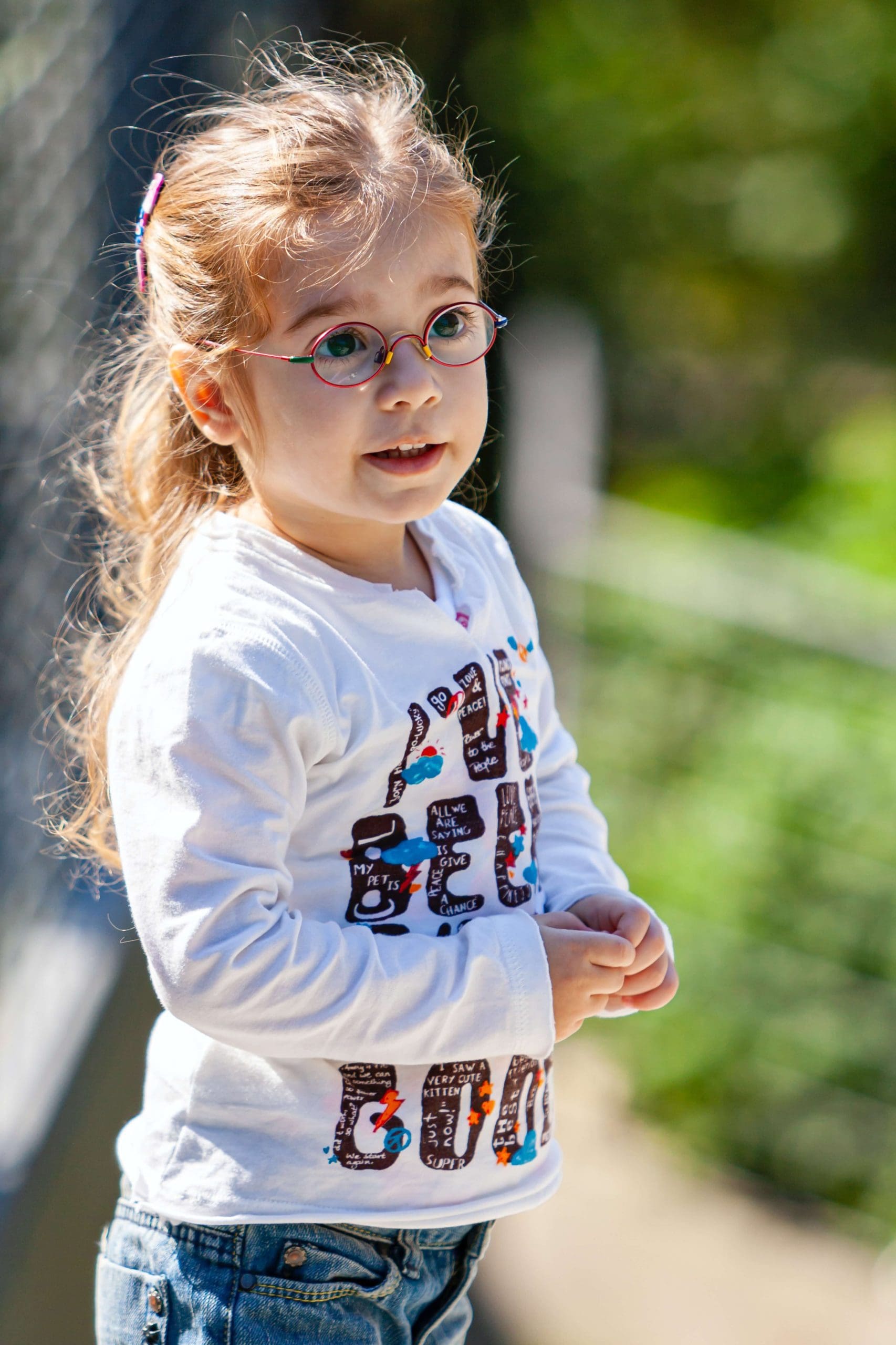 Young girl with glasses outside on a sunny day